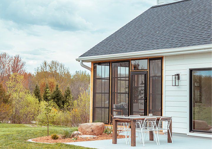 Exterior sunroom enclosure with large sliding windows and a patio door